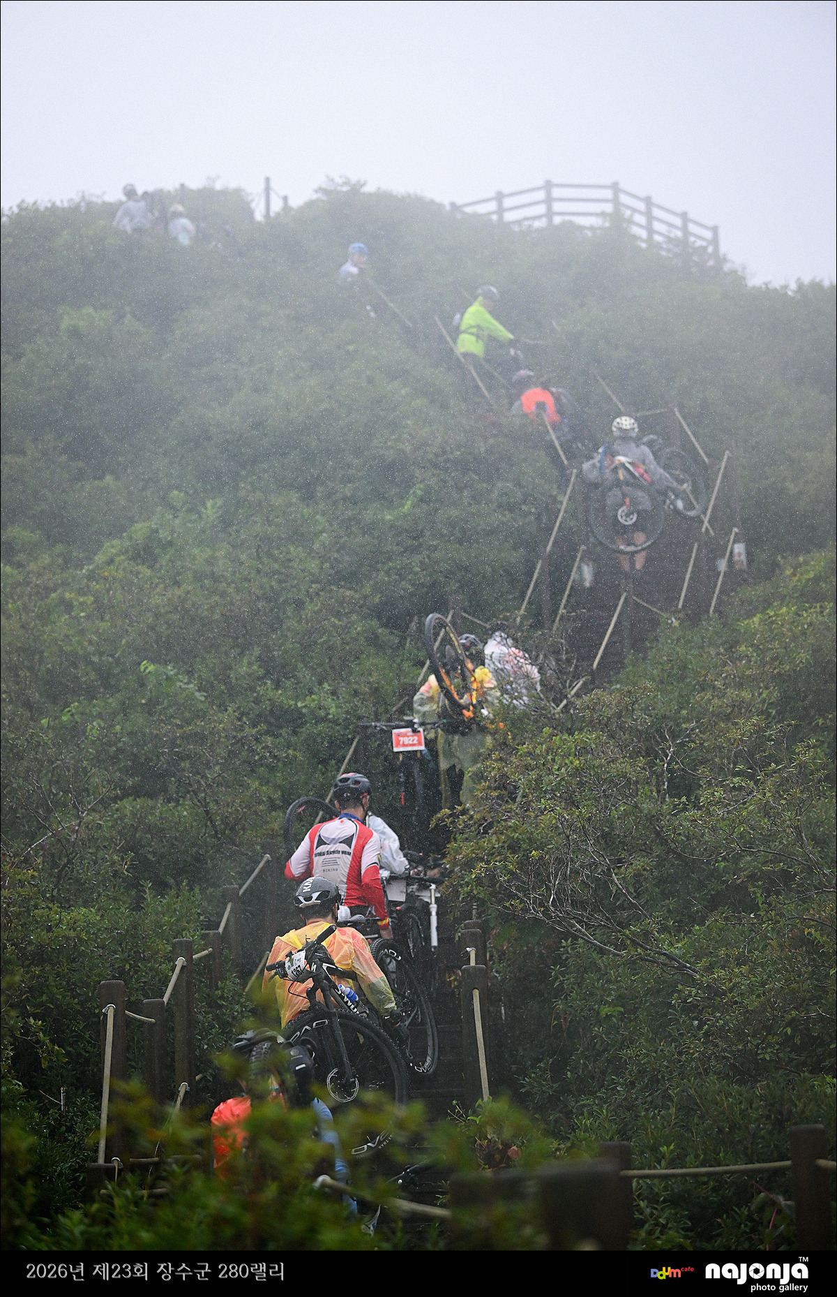 280 Rally riders carrying bikes through a wet mountain section